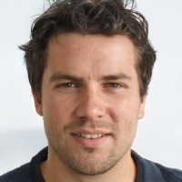 A man with dark hair smiling.